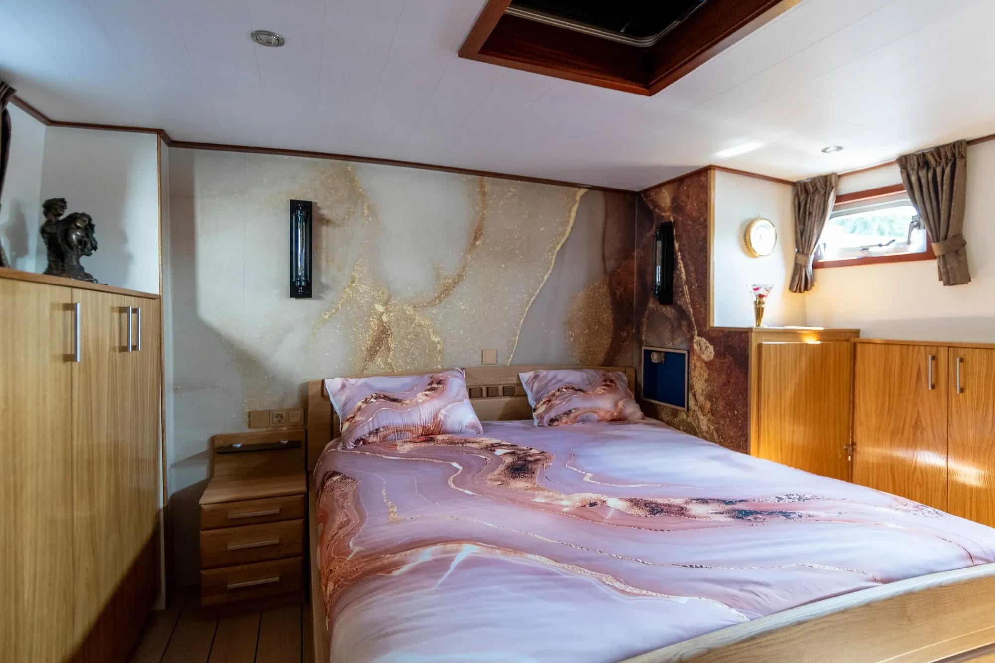 Een slaapkamer met bed, houten afwerking en een donkere accentwand.